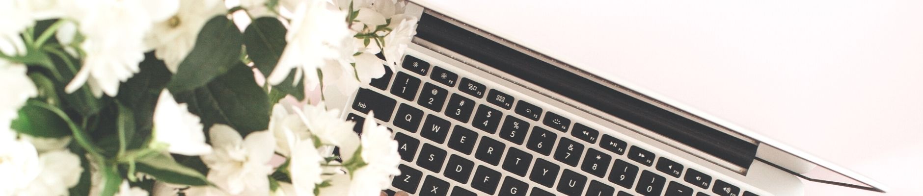 Close up image of a laptop and white flowers